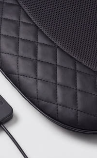 Close-up of the massage seat pad's quilted leather and mesh fabric texture
